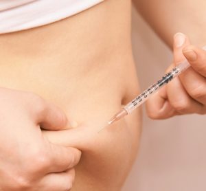 Woman injecting substance in the abdominal area