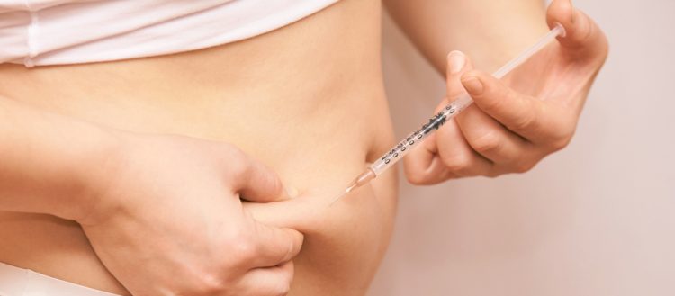 Woman injecting substance in the abdominal area