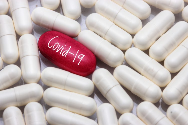 White pills surrounding one red pill that is labelled Covid-19