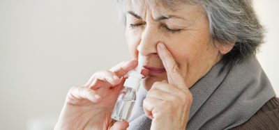 Elderly woman using nose spary