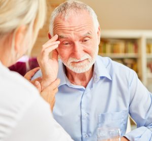 Older man with dementia sitting with nurse