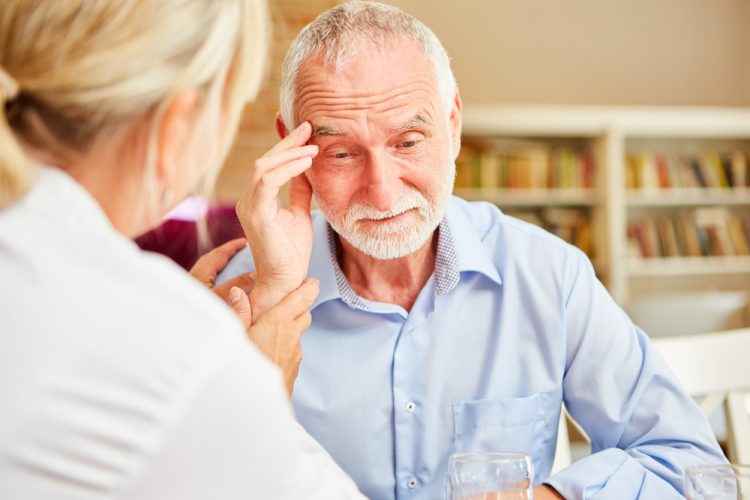 Older man with dementia sitting with nurse