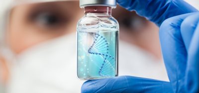 Scientist holding a vial with a digital DNA helix illustration, symbolising advanced gene therapy research