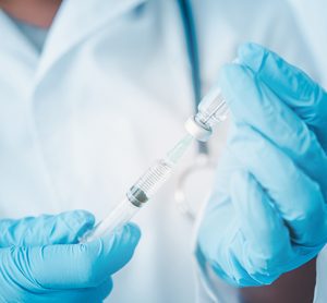 Doctor with syringe ready for injection of vaccine to patient.