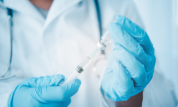 Doctor with syringe ready for injection of vaccine to patient.