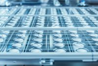 Macro Shot of White Pills During Production and Packing Process on Modern Pharmaceutical Factory. Medical Drug Manufacturing.