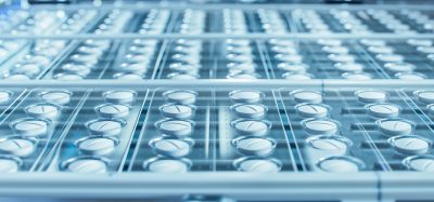 Macro Shot of White Pills During Production and Packing Process on Modern Pharmaceutical Factory. Medical Drug Manufacturing.