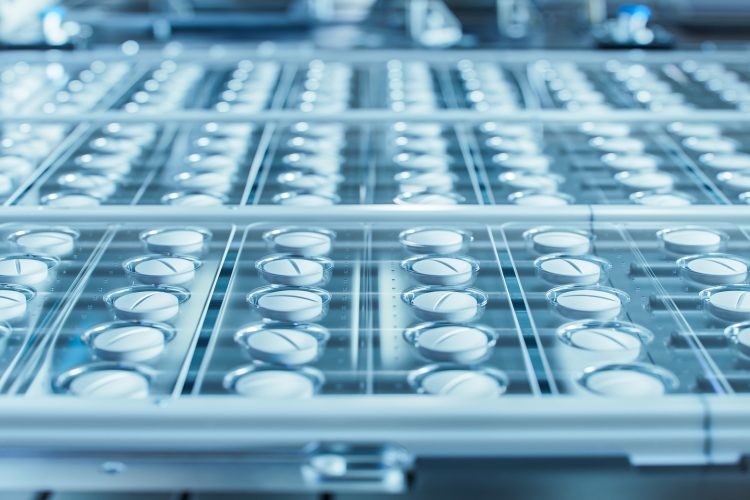 Macro Shot of White Pills During Production and Packing Process on Modern Pharmaceutical Factory. Medical Drug Manufacturing.