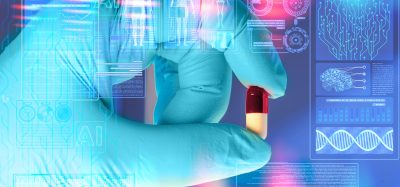 Gloved hand holding a capsule surrounded by digital AI and molecular biology interfaces, symbolising artificial intelligence–driven drug discovery and targeting previously undruggable diseases