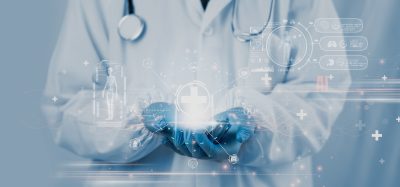 A doctor holding a glowing digital interface with medical and AI icons, symbolizing the integration of artificial intelligence and real-time data in modern healthcare and pharmaceutical innovation.