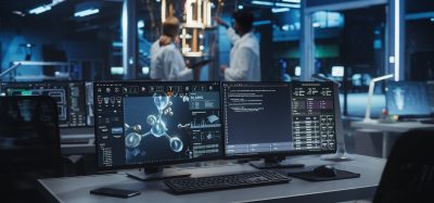 Computer monitors displaying molecular simulations and analysis software in a modern research lab, illustrating computational drug discovery workflows