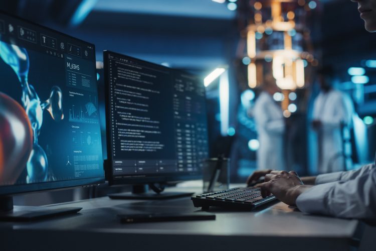 Anonymous Medical Researcher Working in Modern Office on a Desktop Computer with Molecular Modelling Software and Source Code on Screen. Biologist Designing New Drug Molecules to Combat Bacteria