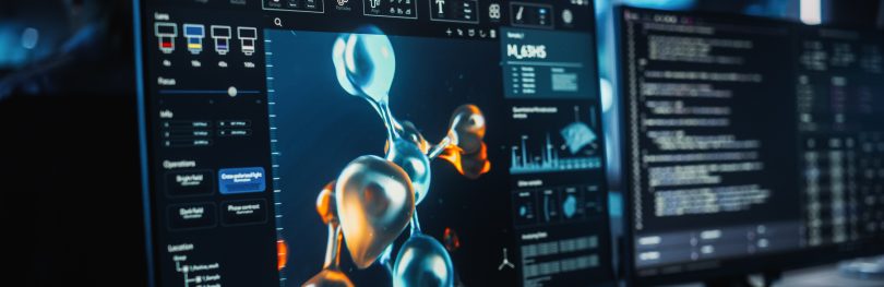 Computer screens displaying a 3D molecular structure simulation used for computational drug discovery and protein modelling.