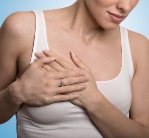 Clothed woman touching breast in pain