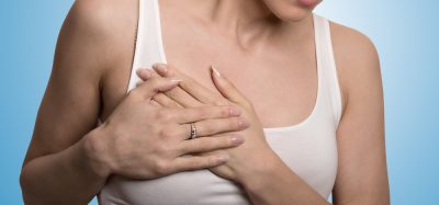 Clothed woman touching breast in pain