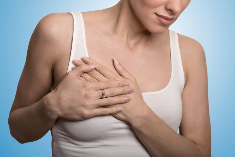 Clothed woman touching breast in pain