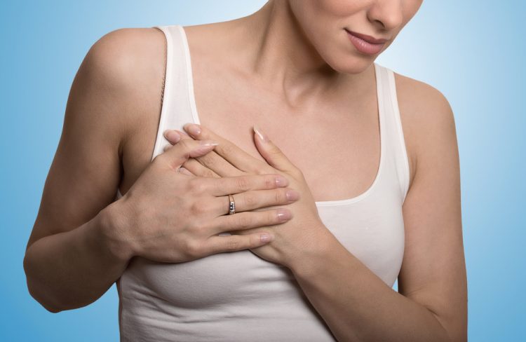 Clothed woman touching breast in pain