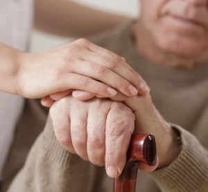 Care worker holding hand of Parkinson's patient