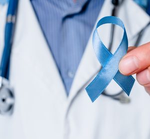 Doctor holding blue ribbon, representing prostate cancer