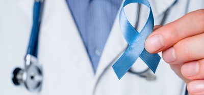 Doctor holding blue ribbon, representing prostate cancer