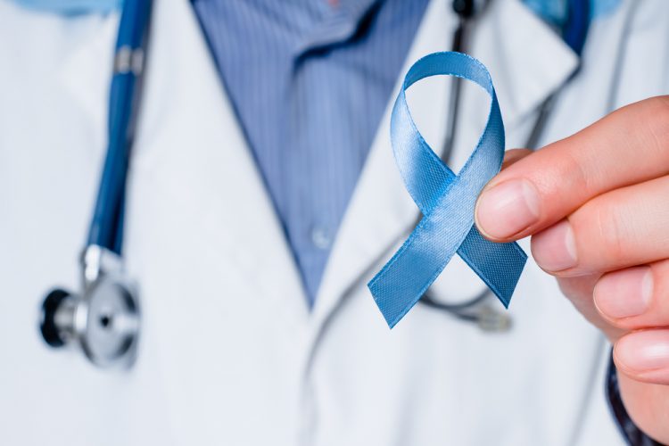 Doctor holding blue ribbon, representing prostate cancer