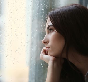 Woman with depression looking out of window