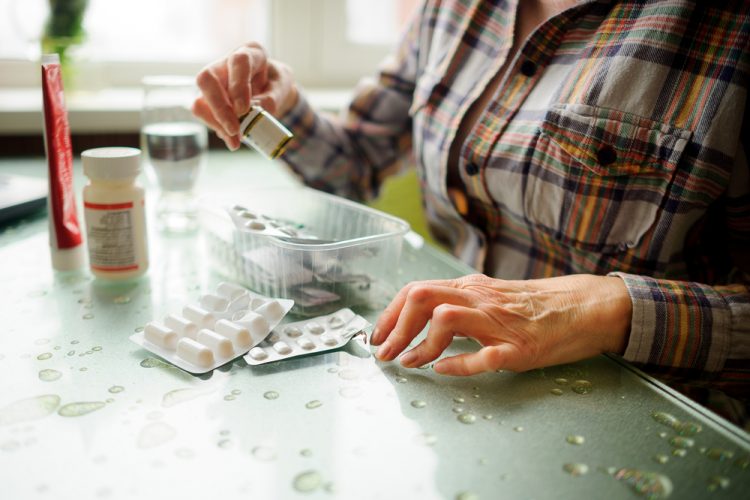 Woman with rheumatoid arthritis chhecking medicines