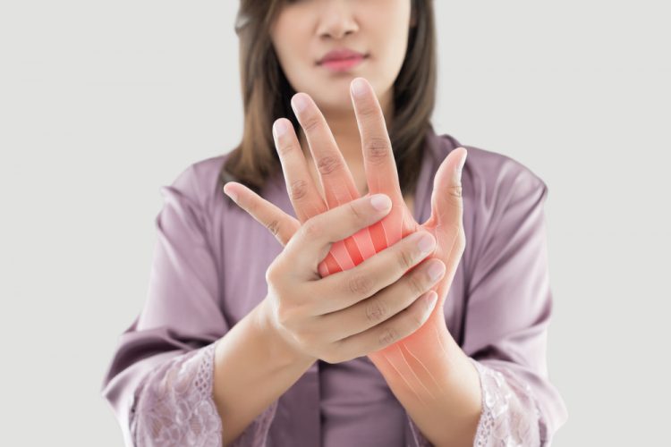 Woman with arthritus holding hand highlighted in red